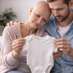 Paar hält Babyschuhe in den Händen – Kinderwunsch trotz Krebsdiagnose