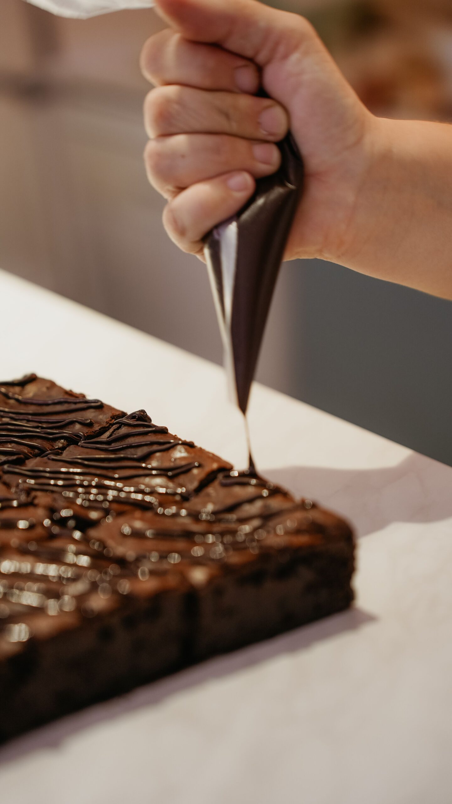 Zuckerfreie Brownies werden mit geschmolzener Schokolade dekoriert.