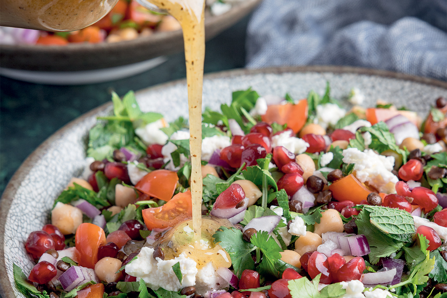 Hausgemachter Linsensalat mit Feta, Granatapfel, Kichererbsen und frischem Dressing wird serviert.
