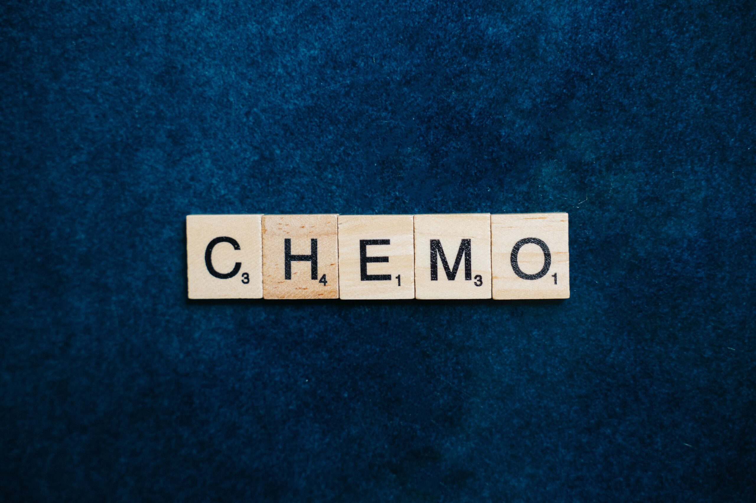 Holzbuchstaben mit dem Wort „Chemo“ auf blauem Hintergrund – Symbolbild für Chemotherapie, Krebsbehandlung und Brustkrebs.