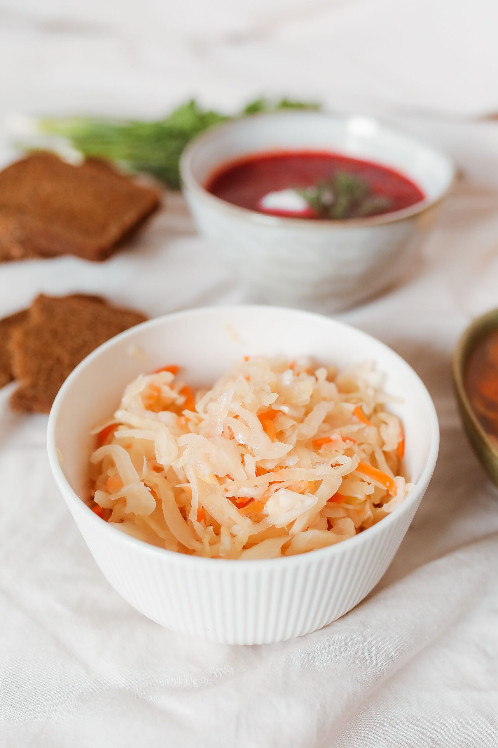 Schale mit frischem Sauerkraut auf einem hell gedeckten Tisch – fermentiertes Lebensmittel zur Unterstützung einer gesunden Darmflora und Verdauung.